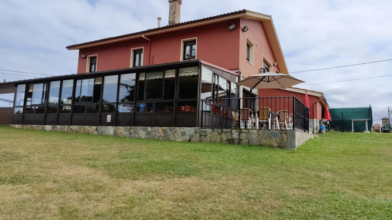 Fachada de bar‑restaurante "La Portiella" con terraza acristalada y jardín